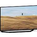 Modern TV Screen Displaying Golden Wheat Field With Single Tree Flying Birds And Blue Sky