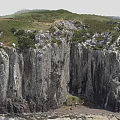 Scenic Coastal Cliff Landscape With Rugged Rock Formations And Green Vegetation