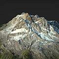 Snowy Mountain Terrain With Towering Peaks Snow Covered Rocks And Green Vegetation