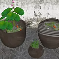 Three Garden Decorative Flower Pots With Green Plants Against Stone Wall And Paved Ground