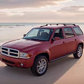 Red SUV Parked On Sandy Beach With Ocean And Sunset Sky