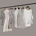 Various Beige White Gray Clothes Hanging On Wooden Hangers With Knitted Sweater And Dress