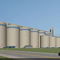 Industrial Plant Featuring Large Silos Green Lawn And Blue Sky With White Clouds