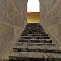 Modern Stone Staircase Design With Hieroglyphic Walls And Natural Light Streaming Through