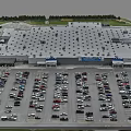 Aerial View of Large Retail Store Parking Lot Full of Cars and Green Surroundings