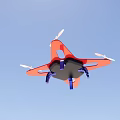 Red Drone Flying in Blue Sky With Four Propellers and Blue Bottom Parts