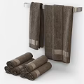 Brown Towels With Silver Trim Hanging On Rack And Rolled For Bathroom Decor