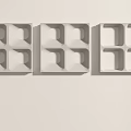 Three White Square Carved Decorations With Geometric Patterns On Light Wall