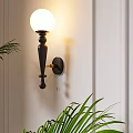 Elegant Black Wall Lamp With White Globe Shade Mounted On Beige Wall And Green Plants