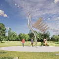 Modern Stainless Steel Landscape Sculpture Resembling Crane in Park Grassland with Trees and People Walking