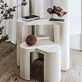 White Minimalist Layered Side Table Decorated With Pine Cone Book And Green Branches