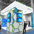 QMF.COM Modern Exhibition Booth With Blue Green Hexagonal Design Display Screens And Professional Staff Interaction