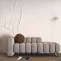 Light Gray Rounded Tufted Chaise Lounge With Brown Textured Pillow And White Textured Wall