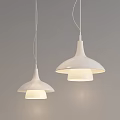 Two White Pendant Lights With Conical Tops And Wide Shades Illuminated On Gray Background Wall
