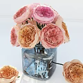 Blooming Pink And Orange Roses In Blue Glass Vase With Scattered Flowers On White Background