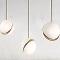 Modern Three Pendant Lights With White Spherical Shades And Gold Edges Hanging On Gold Chains