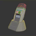 Gray Handheld Device With Digital Display Yellow Buttons And Charging Stand