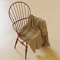 Wooden Spindle Back Leisure Chair With Knitted Blanket On Light Wood Herringbone Floor