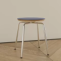 Modern Minimalist Stool With Blue Round Seat And Silver Metal Cross Legs On Wooden Floor