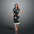 Woman in Green Dress With White Floral Patterns And Lace Hem Standing Against Gray Background
