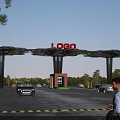 Modern Entrance Gate With LOGO Sign Canopy Structure Cars And Trees In Parking Area