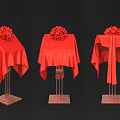 Red Tablecloths With Flower Arrangements On Metal Stands Against Black Background