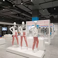 Modern Clothing Store Displaying Three Mannequins in Pink Pants on White Platforms with Hanging Clothes 3d model