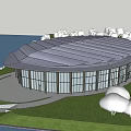 Modern Circular Glass Building Exterior With Scenic Waterfront And Green Grass