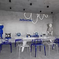 Modern Interior Space Featuring Transparent Chairs Blue Bases White Table Collectible Figures And Pendant Lights