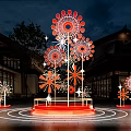 Outdoor Flower Shaped Art Installation with Red White Petals Illuminated at Night Against Building Background