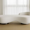 White Irregular Shaped Sofa In Modern Minimalist Room With Natural Light