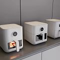 Three White Modern Kitchen Air Fryers On Gray Countertop With Cabinets