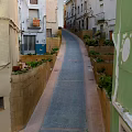 Urban Roadway Infrastructure Featuring Narrow Street With Buildings Plants And Colored Walls