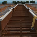 Construction Site Foundation Work In Progress With Yellow Excavator And Steel Beams