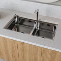 Double Bowl Stainless Steel Kitchen Sink with Modern Faucet on Light Countertop and Wooden Cabinets