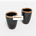 Two Black Cylindrical Ceramic Vessels with Brown Rimmed Accents on White Background