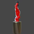 White Statue With Blue Red Arms Holding Circular Object Above Head On Silver Cylindrical Base