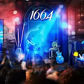 Vibrant Bar With 1664 Live Music Stage Blue Red Lighting Screen And Audience