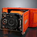 Vintage Camera With Orange Leather Case Black Lens And Folding Design