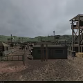 Arid Desert Landscape With Watchtower Simple Buildings Fence And Distant Mountains