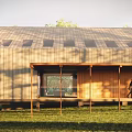 Modern Wooden Single Family House In Grassy Area With Trees And Walking Family