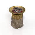 Stone Pedestal With Brass Bowl Filled With Black Charcoal Pieces And Ornate Gold Carvings On Base