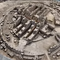 Ancient Stone Ruins With Circular Stone Walls And Scattered Blocks In Archaeological Site