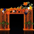 Event Archway with Orange Frame Decorated by Colorful Flowers and Green Plants