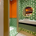 Vibrant Orange Restaurant Interior With Green Booths Dining Tables And Plant Decorations