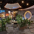 JOHOBUS Bar Restaurant Interior With Lush Plants Circular Decoration Lighting And Pebble Floor