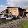 Traditional Guesthouse Building With Stone Walls Wooden Roof Surrounded by Green Lawn and Trees