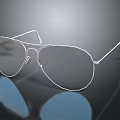Silver Metallic Jewelry Glasses With Dark Lenses And Blue Reflective Effect On Black Surface