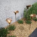 Stylish Petal Shaped Outdoor Lights Illuminating Garden With Green Shrubs And Gravel