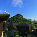 Residential Houses With Dark Roofs Lush Green Hills City Skyline Blue Sky And White Clouds